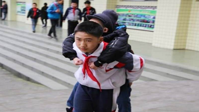 Boy Carries Disabled Friend To School