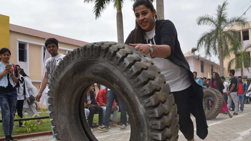 Girl pushing tyre in college